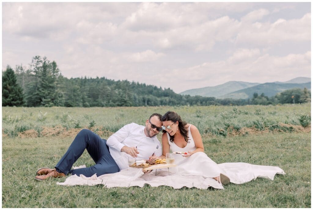 Intimate wedding picnic with snacks and cake after vows in a field among the mountains in Keene, NY.