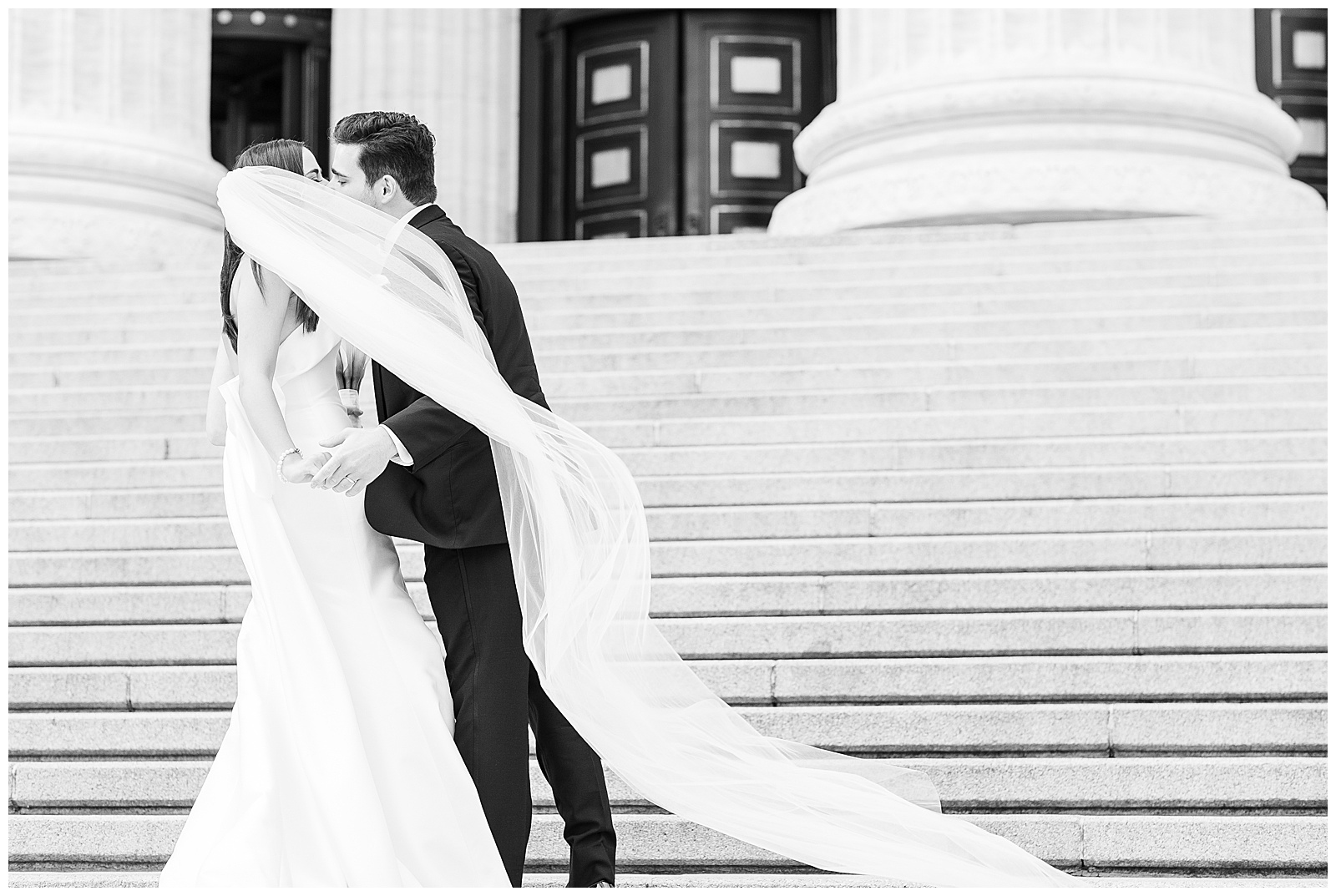 Wedding portrait of couple kissing on the steps of the Education Building in Downtown Albany