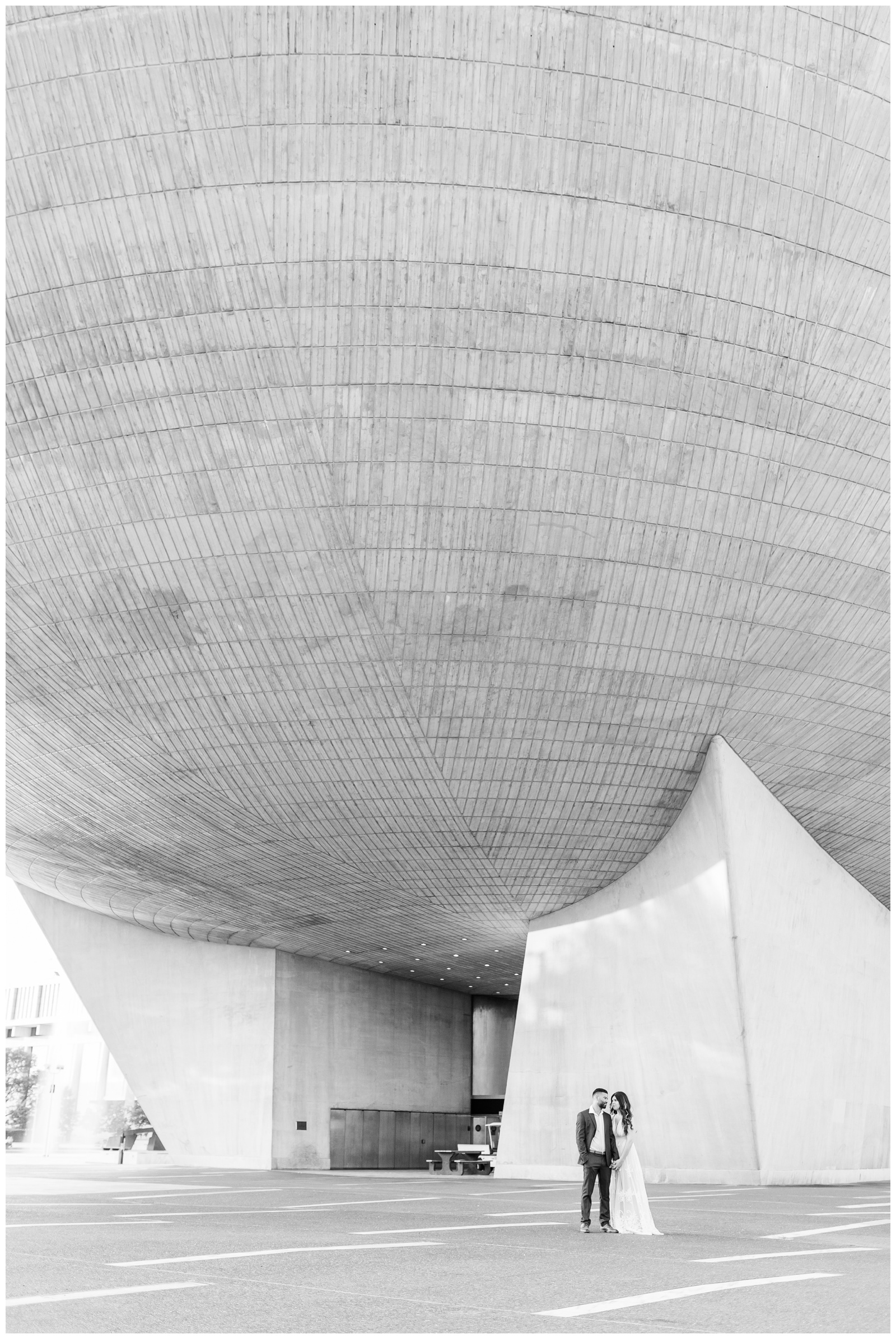 Engaged couple posing for their engagement photos in front of The Egg in downtown Albany, NY