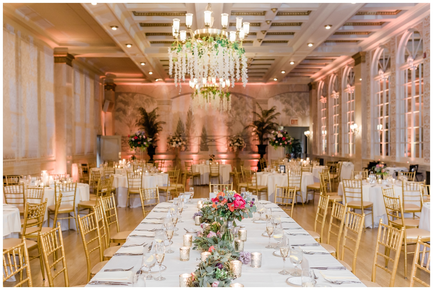 The wedding reception space at Franklin Plaza ballroom in Troy, NY. Decorated with bright colorful floral arrangements and greenery at every table.