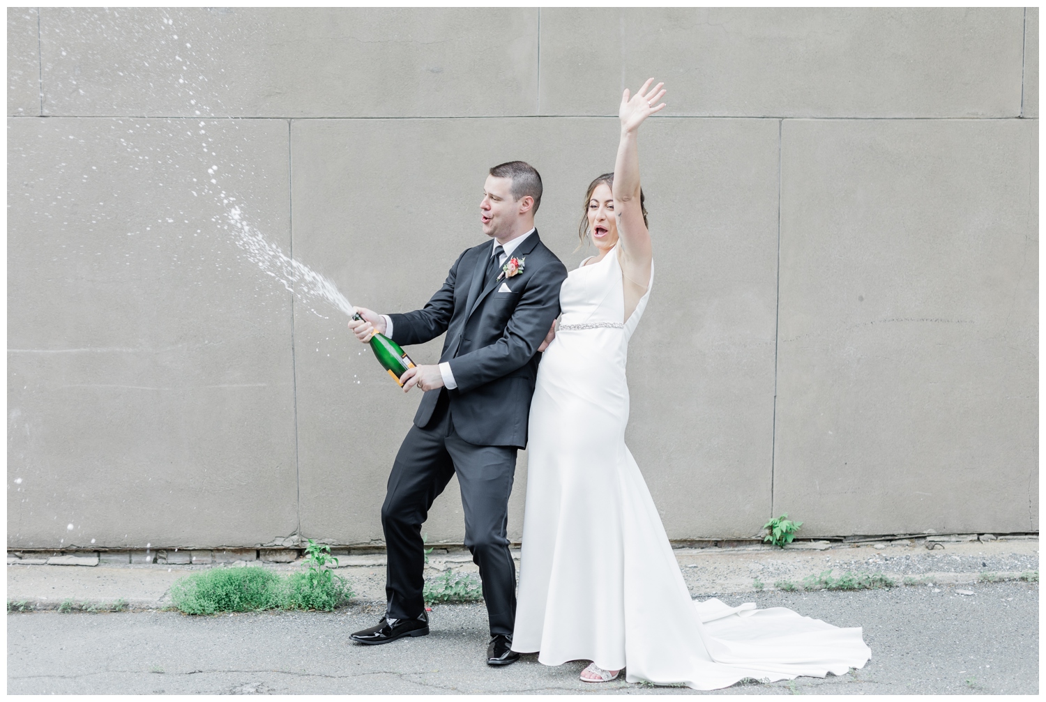Just married couple popping champagne in downtown Troy, NY in celebration of their wedding.