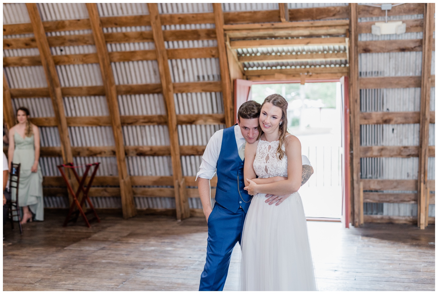 Bride and Groom snuggling up together during toasts and speeches at their barn wedding.
