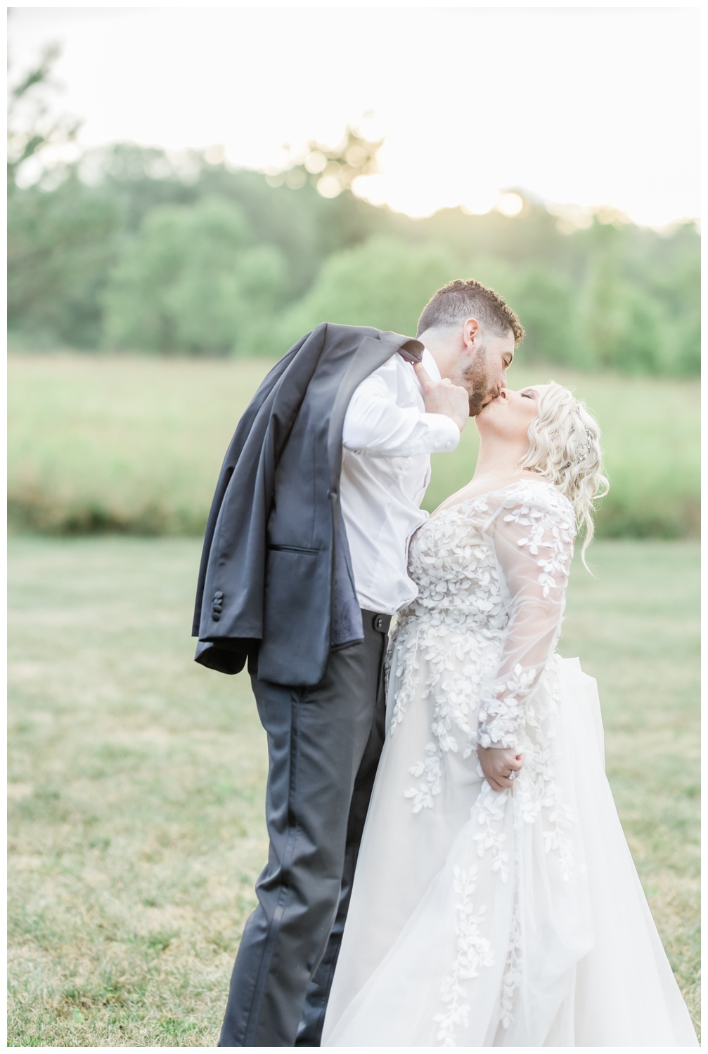 Bride and Groom kissing in front of the sunset on the evening of their intimate wedding day. Photographed in a light and airy style by Nicole Weeks Photography who is based in Saratoga Springs, NY.