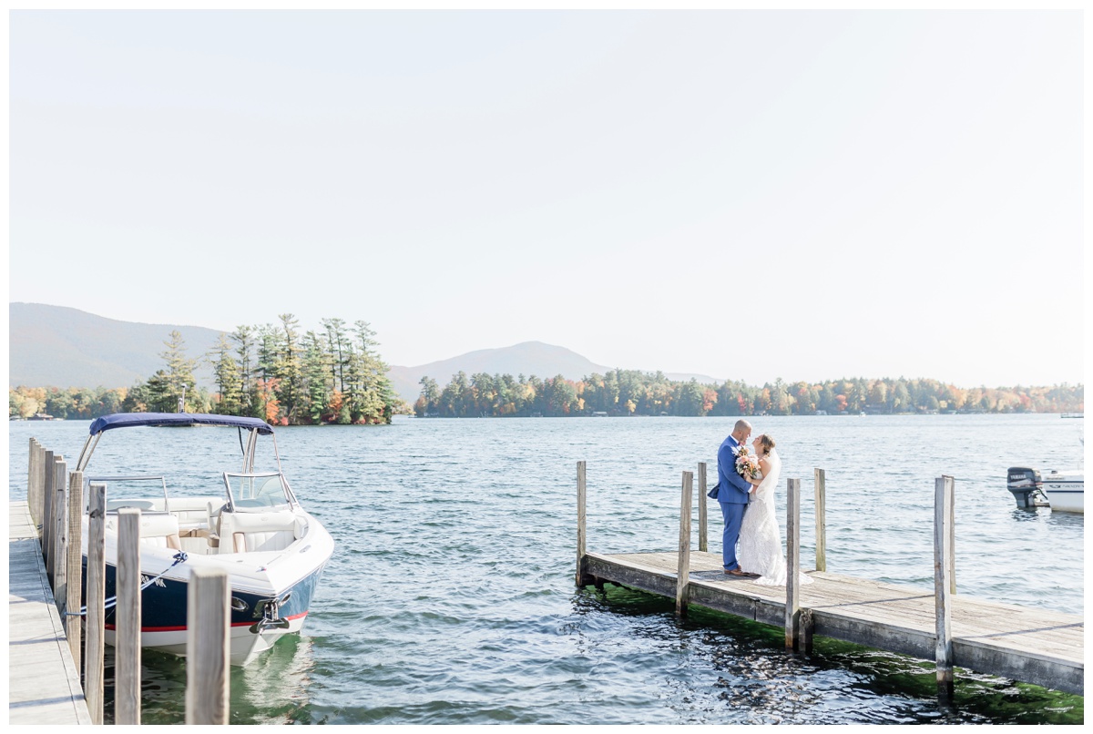  Bride and Groom standing on a dock in Lake George gazing at each other during their elopement in Upstate New York in the Fall.
