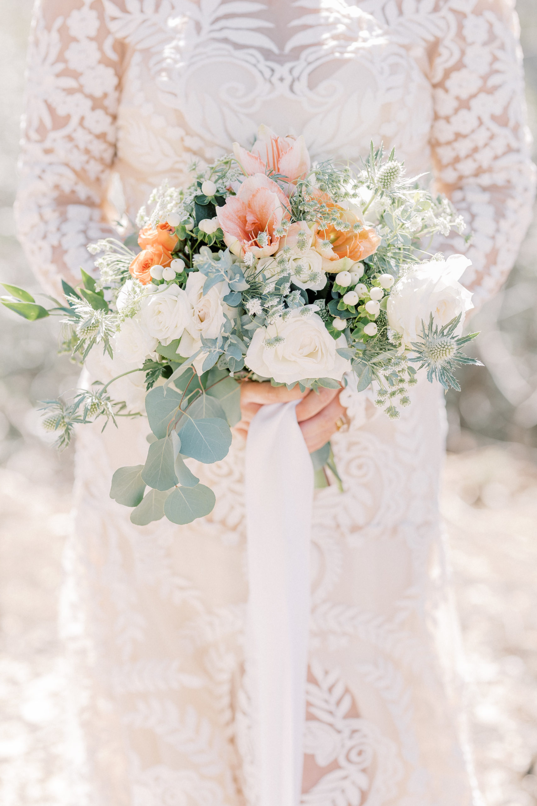 Wedding bouquet with pink, peach and white flowers. Accented with greenery and eucalyptus springs.