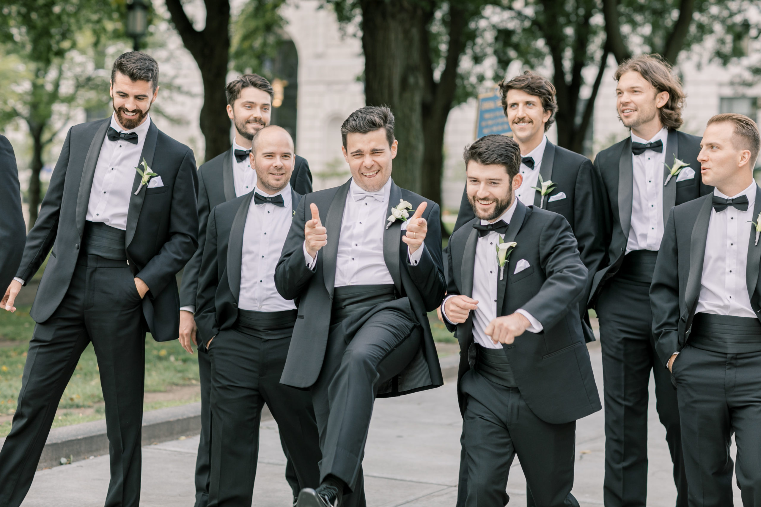 Groom and groomsmen casually walking down the sidewalk on a wedding day. After using my wedding day emergency kit to sew back on some suit buttons, they were all happy and having a great time.