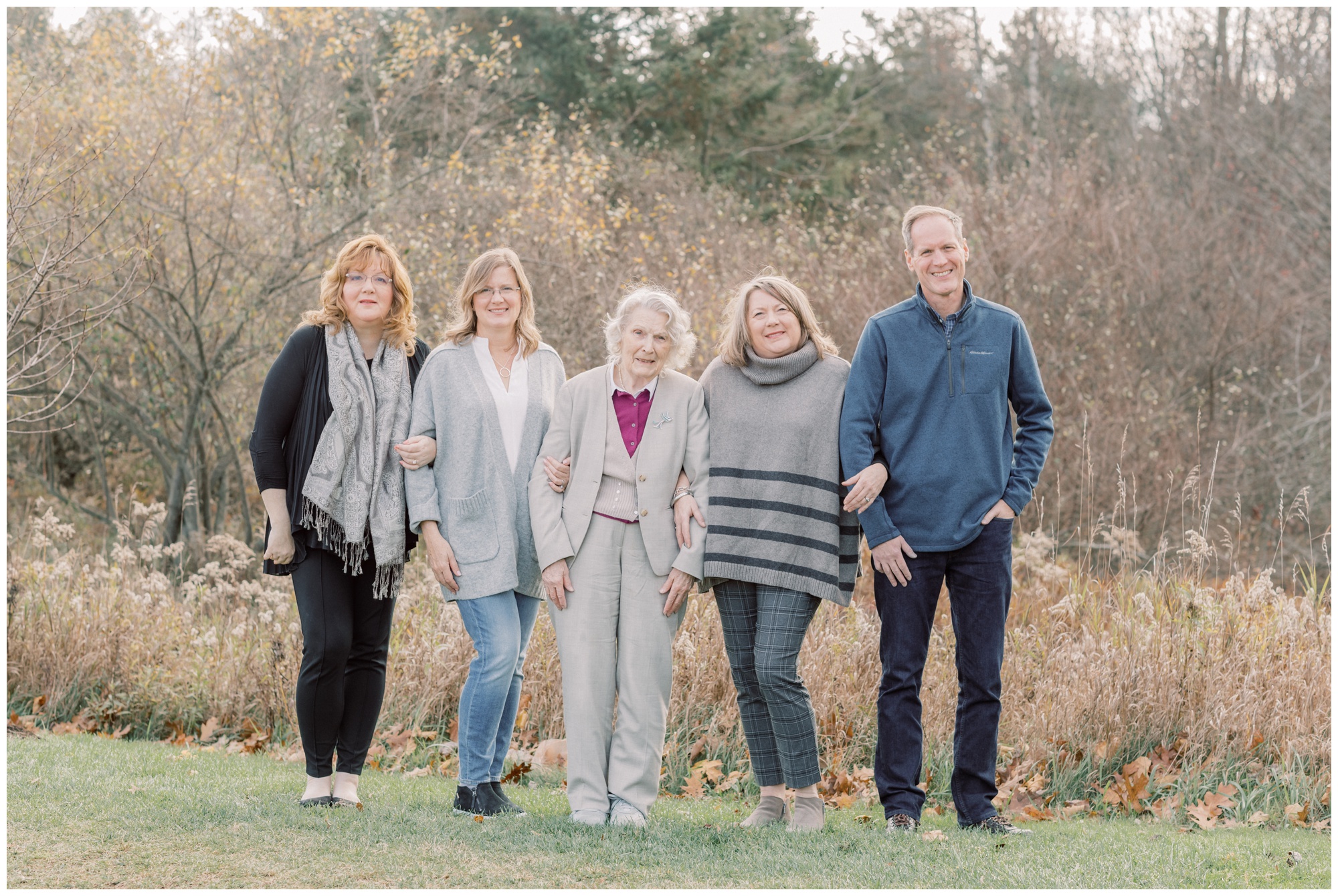 Adult children with their elderly mother smiling during their family portraits in Saratoga springs, NY during the Fall season.
