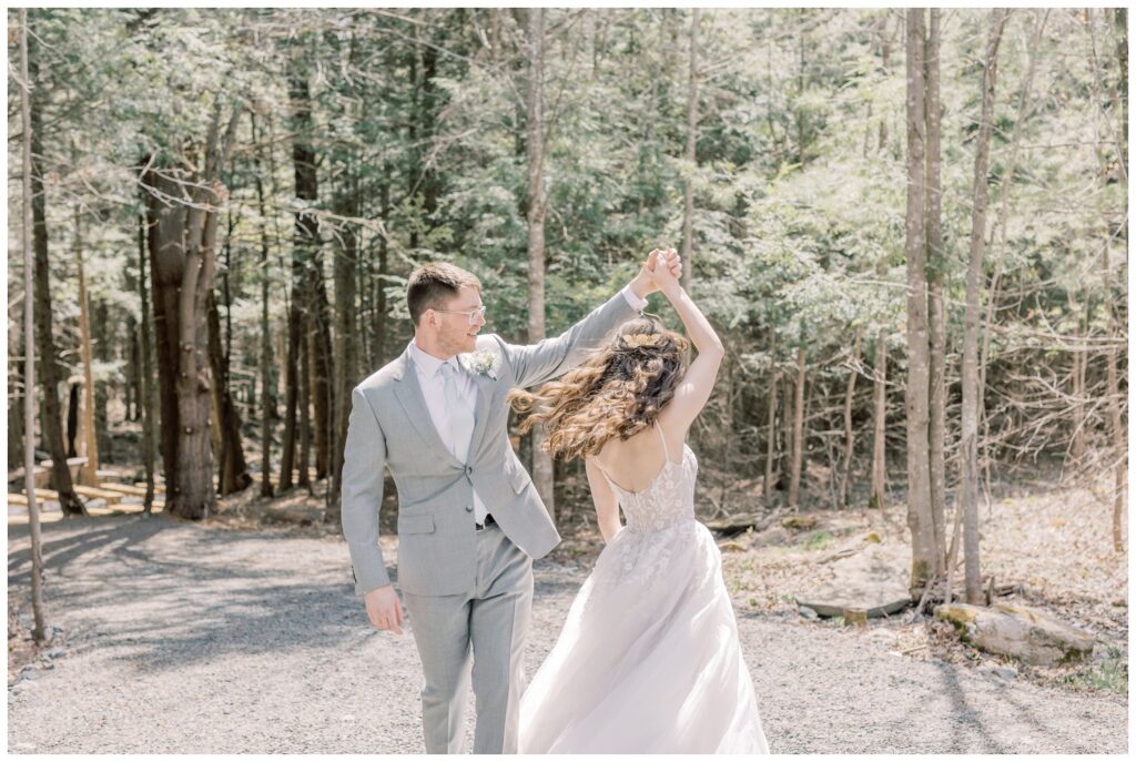 Groom spinning bride during their elopement in the woods of Adirondack mountains. 