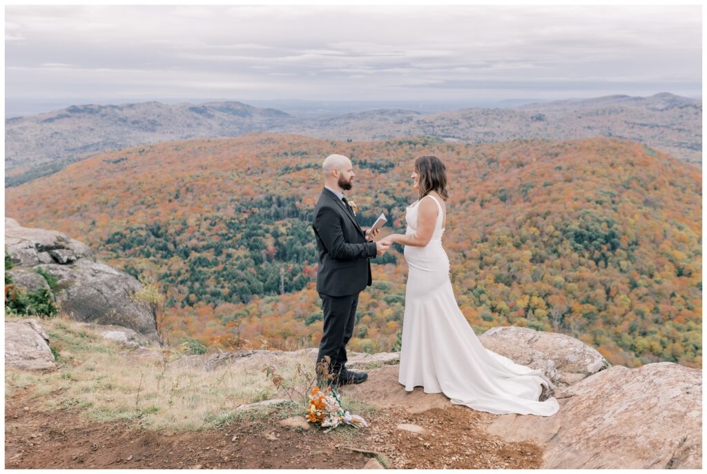 A joyful couple exchanging vows in a serene outdoor setting during their intimate weekday wedding elopement in the Adirondacks.