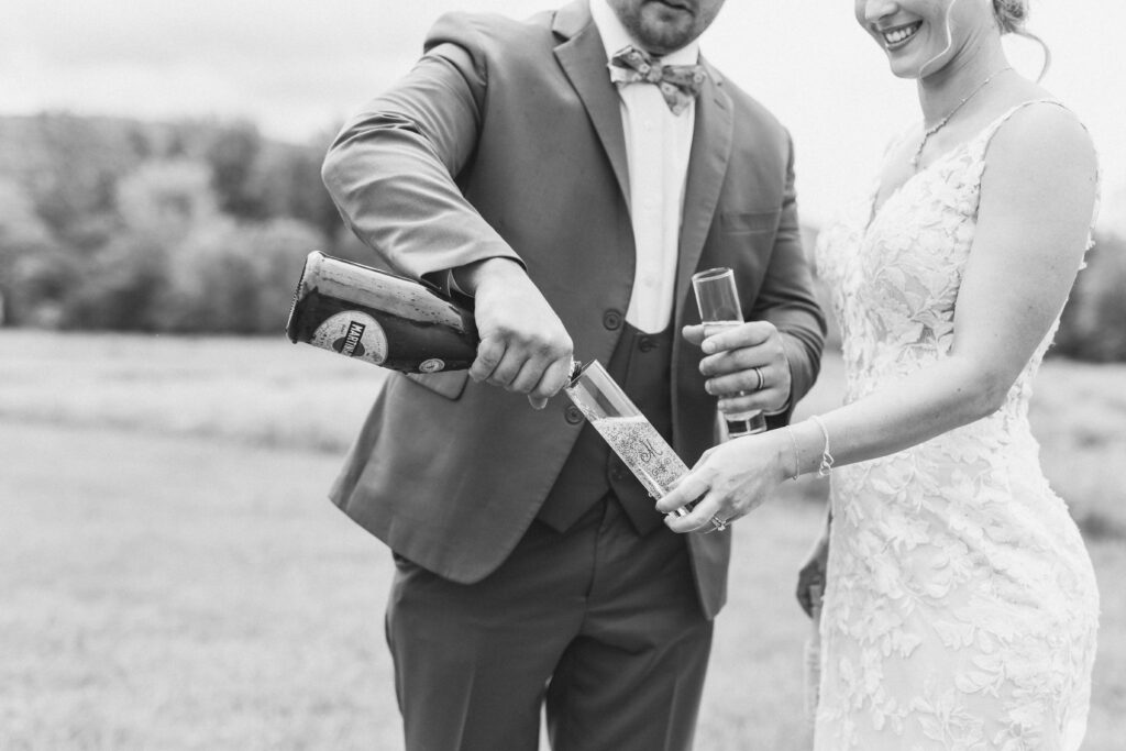 Groom pouring his bride a glass of champagne to celebrate their weekday wedding elopement