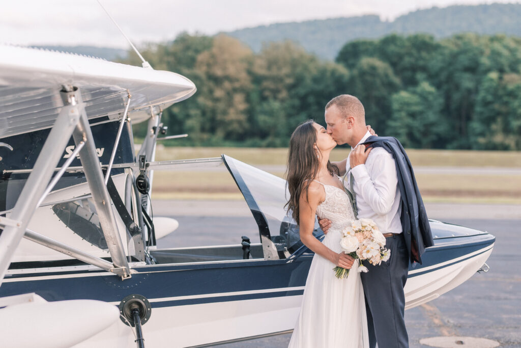 bride and groom portrait in front of a small airplane