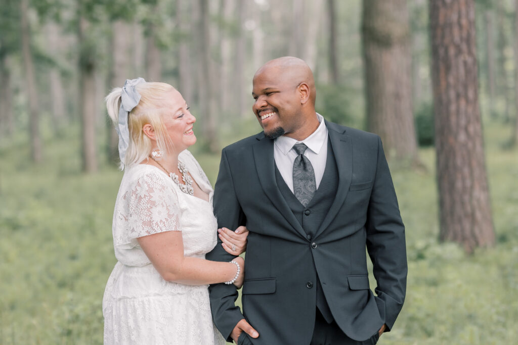 Mixed race couple smiling at each other at Saratoga State Park during their elopement in Upstate New York.