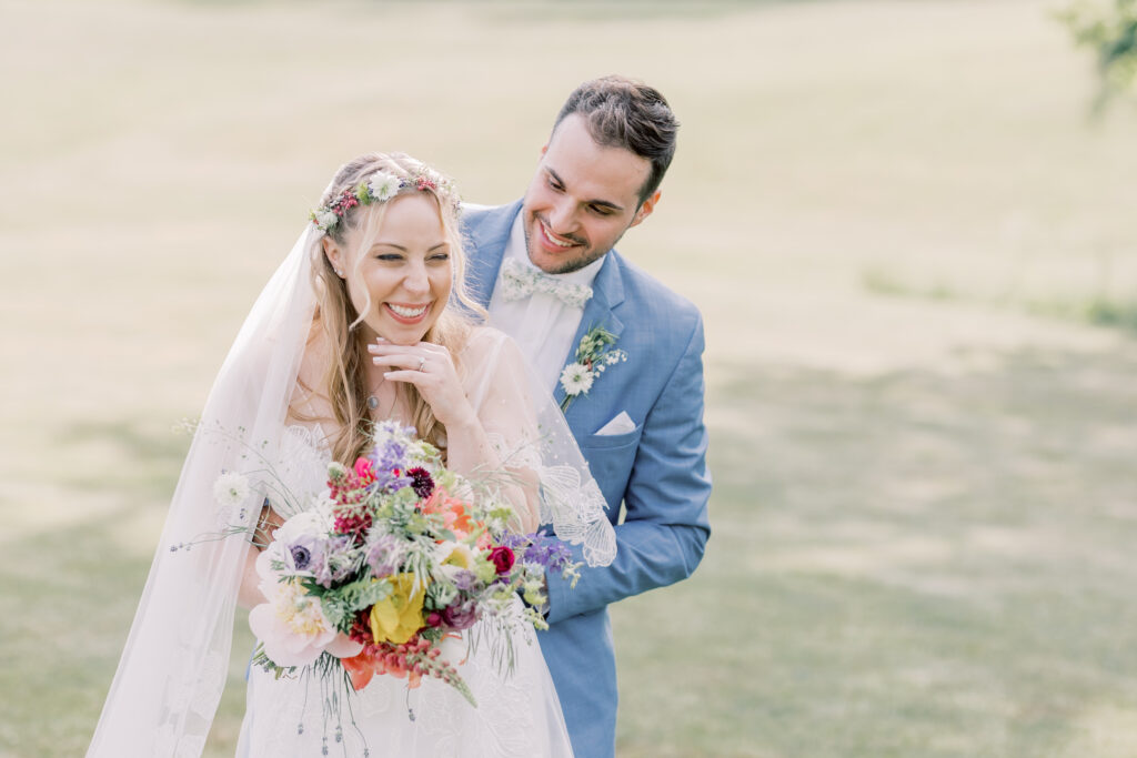 a happy bride and groom photo, with the bride holding her spring elopement bouquet