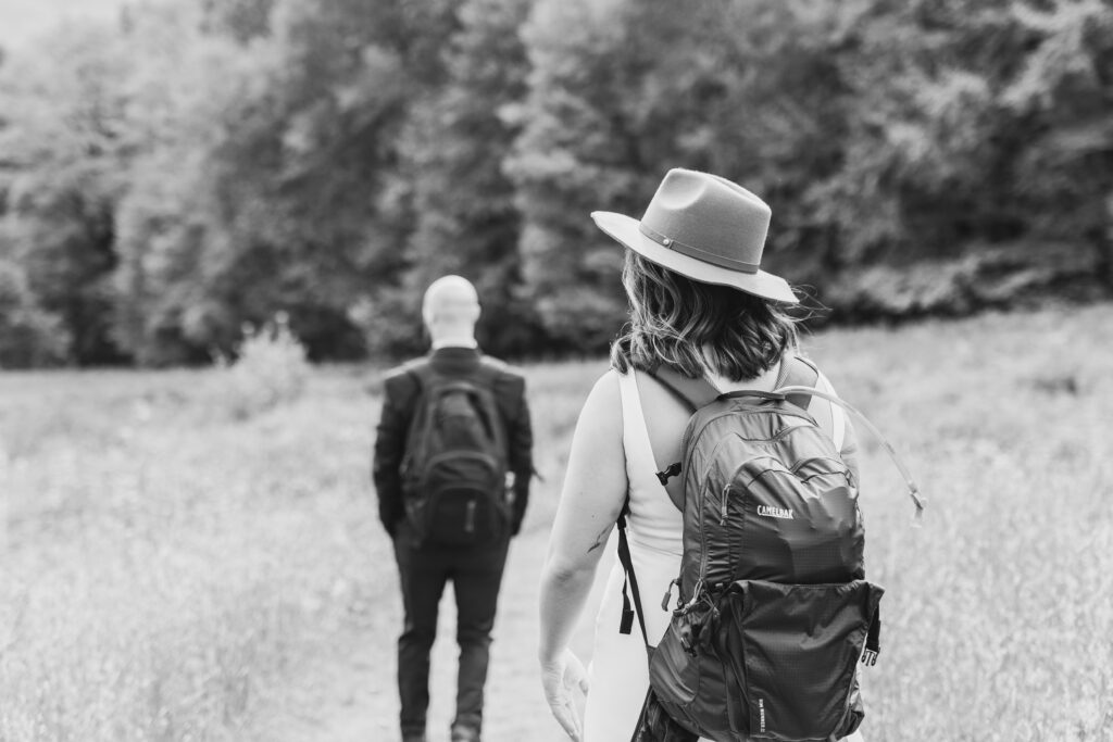 bride and groom with backpacks on preparing to go on a hike