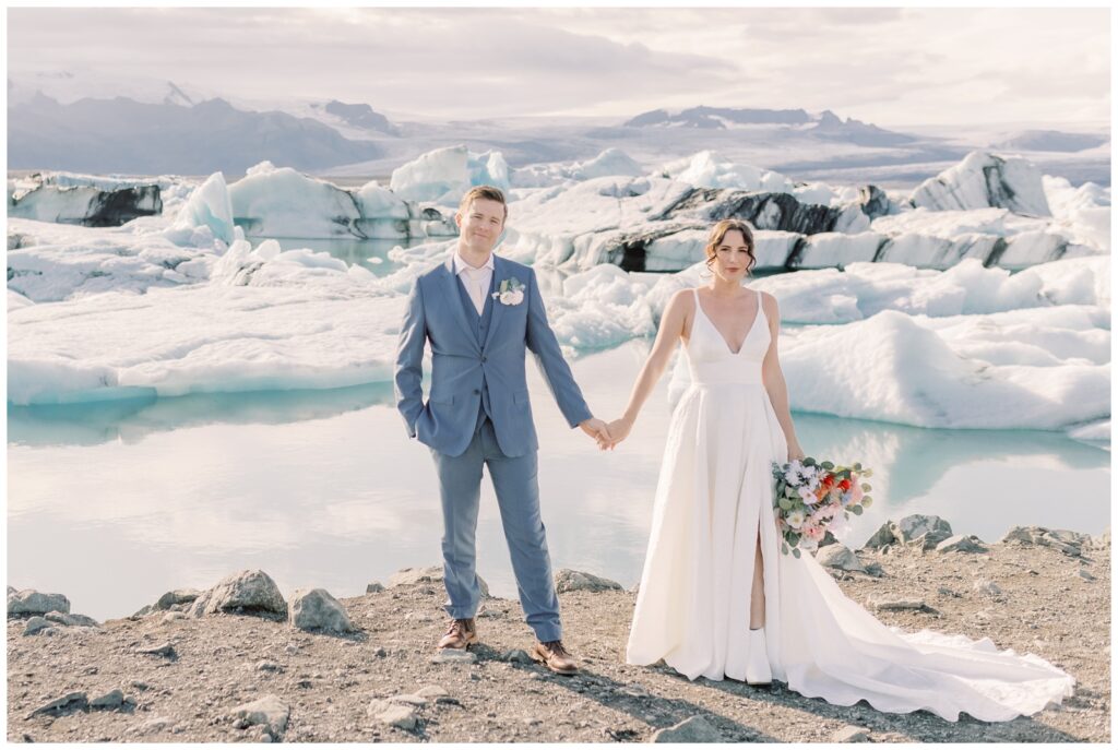 A couple holding hands on during their elopement at Jökulsárlón Glacier Lagoon in Iceland.