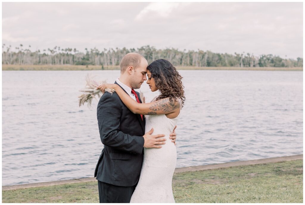 Couple pressing foreheads together in Crystal River my the water.
