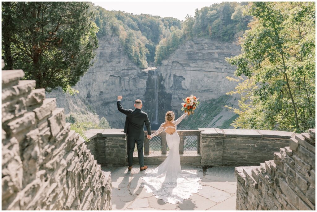 Bride and Groom celebrating at the Overlook at Taughannock Falls by the waterfall in Ithaca, NY.
