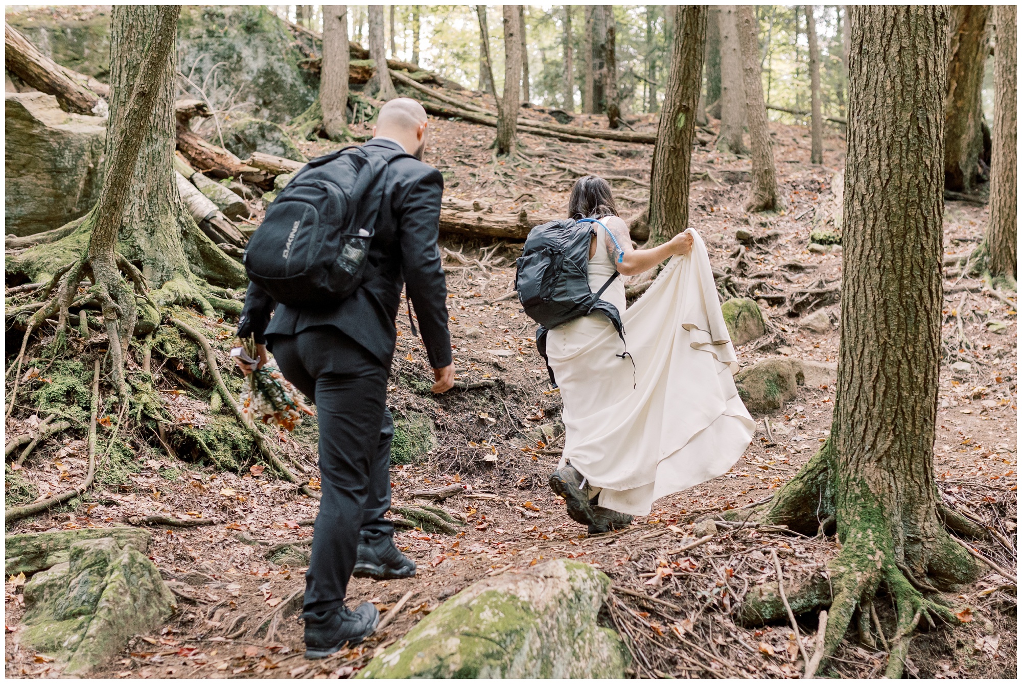 Bride and groom hiking in their wedding attire on their way to their intimate ceremony for their Lake George Adventure Elopement.
