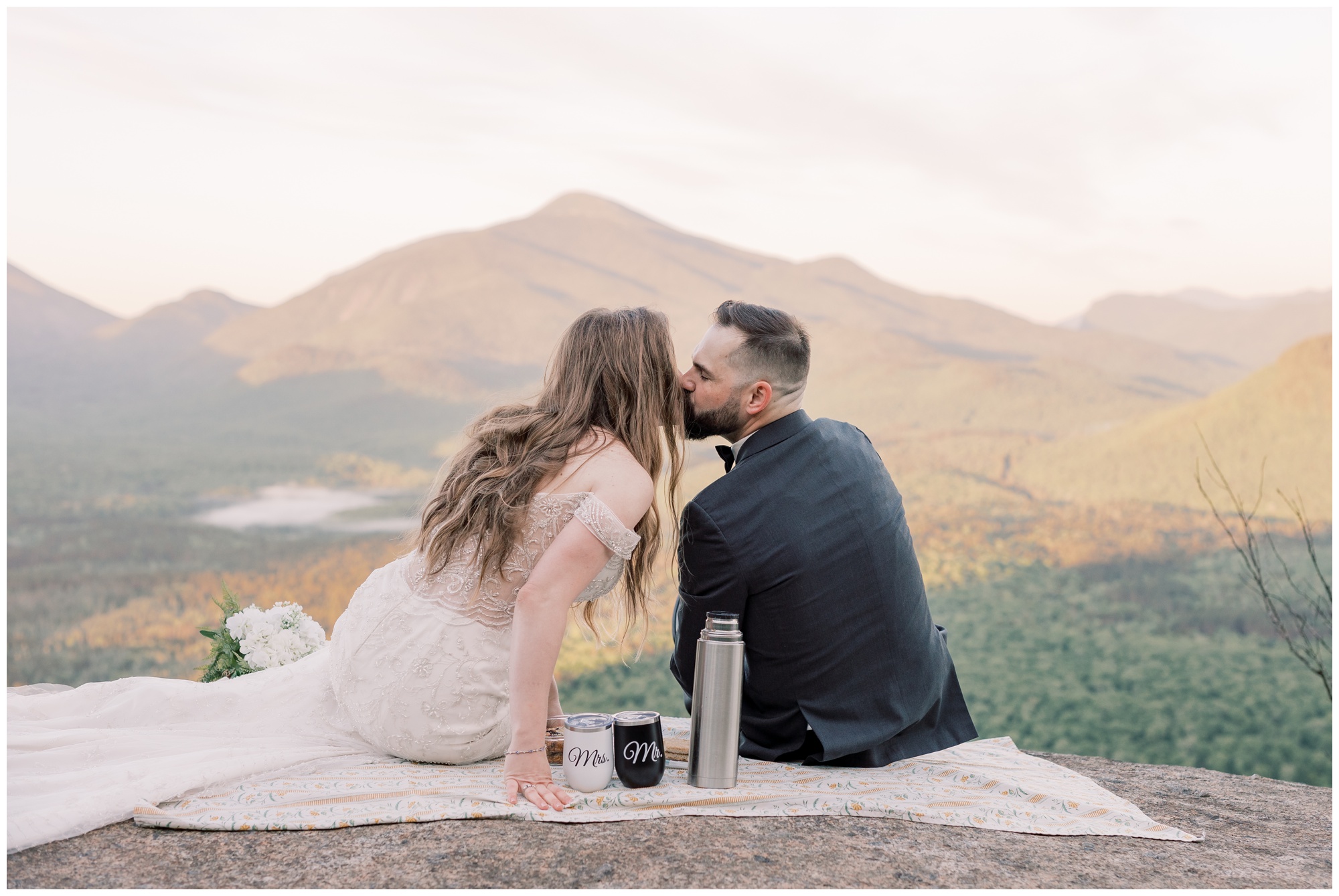 Bride and groom having a picnic during sunrise on top of a mountain. 
