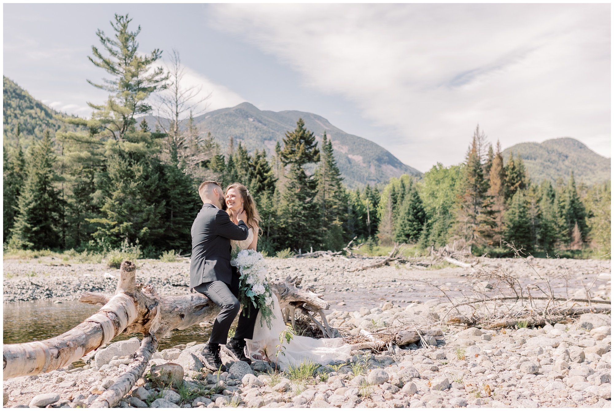 A couple sitting together on a fallen tree during their intimate Lake Placid elopement.

