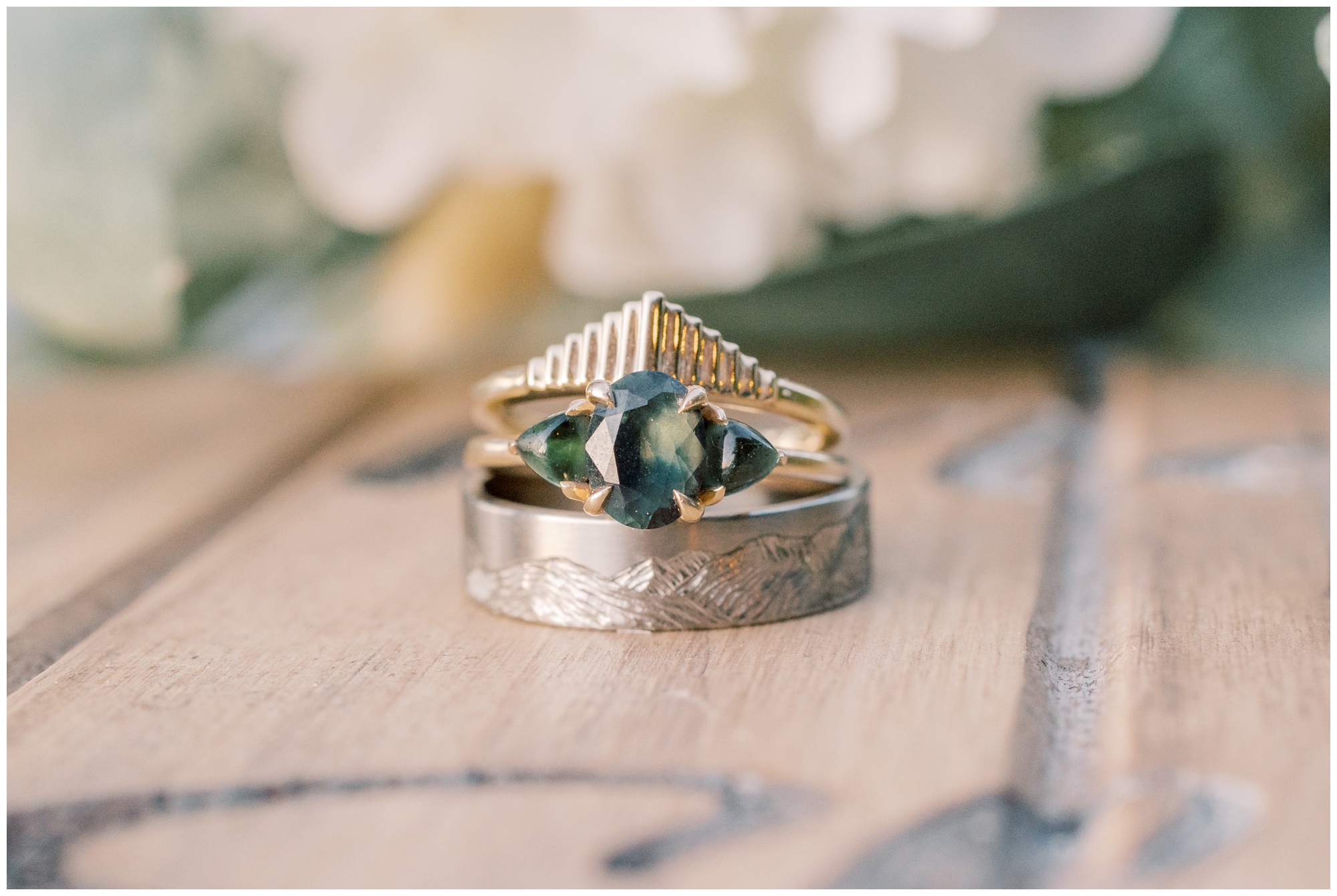 Two wedding rings and one engagement ring stacked together. 
