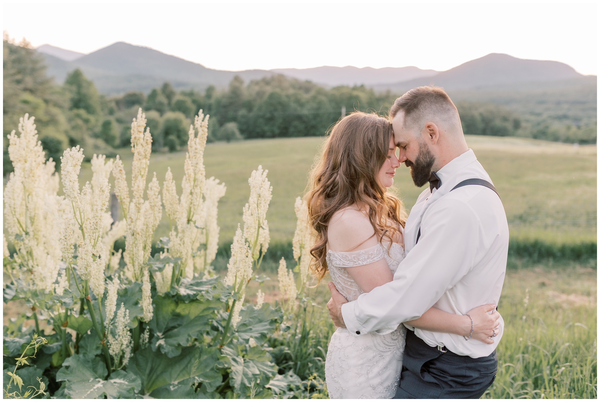 Bride and groom pressing foreheads together during sunset.
