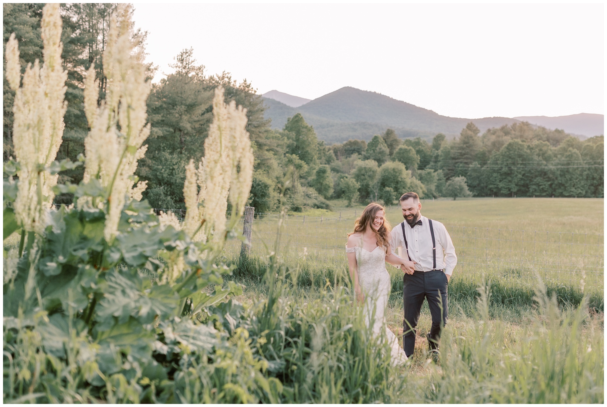 Couple running through a field with mountains in the background during their Intimate Lake Placid Elopement.
