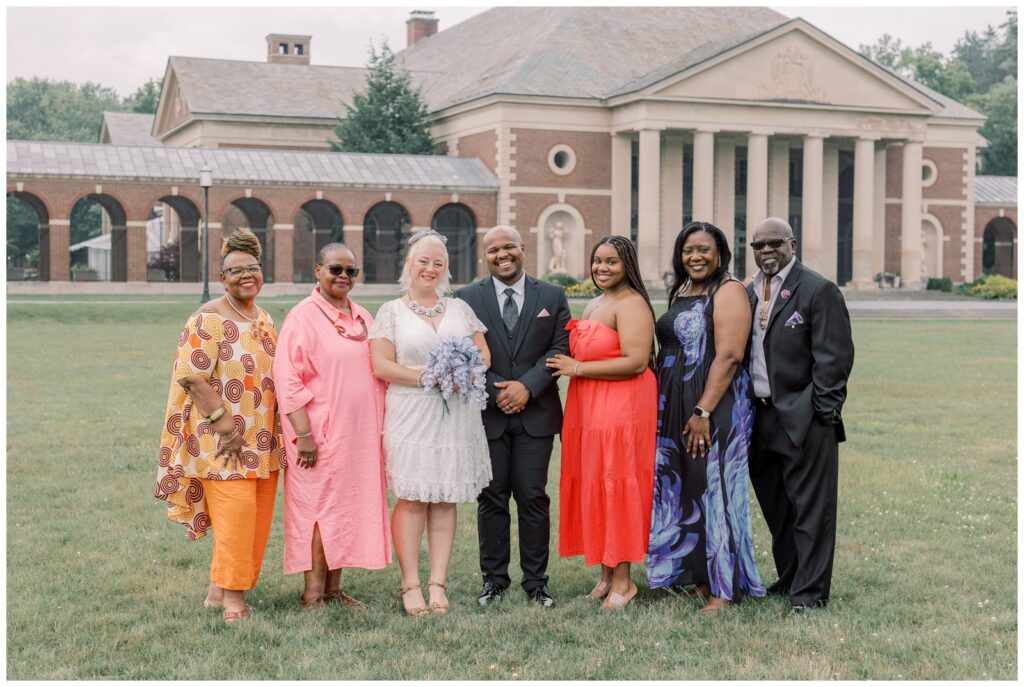 Interracial family poses for a photo in front of the Lincoln Baths at Saratoga State Park during an intimate elopement.
