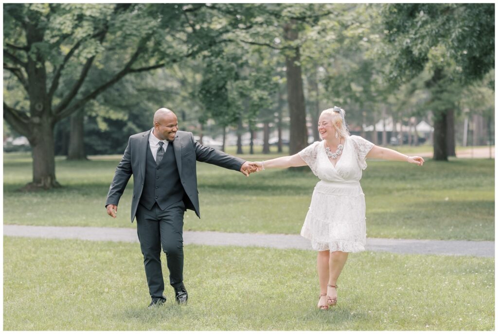 A mixed race couple runs through a field at Saratoga State Park as they make the most of out their elopement.