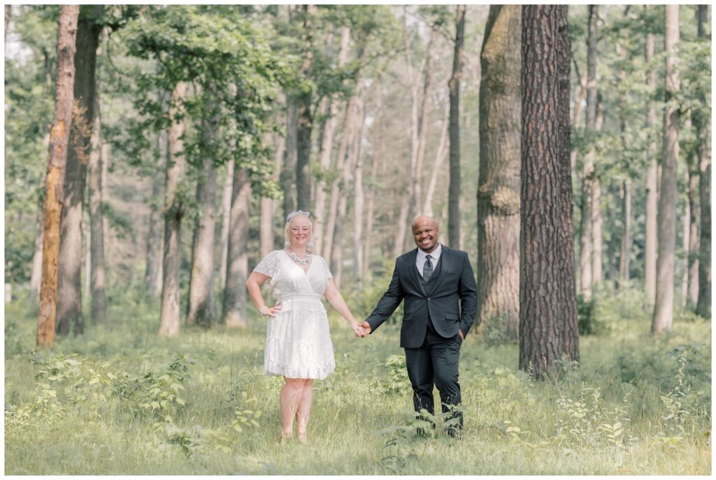 Bride and groom hold hands in the forest of Saratoga State Park. This blog talks about why Saratoga State Park is the perfect elopement location.