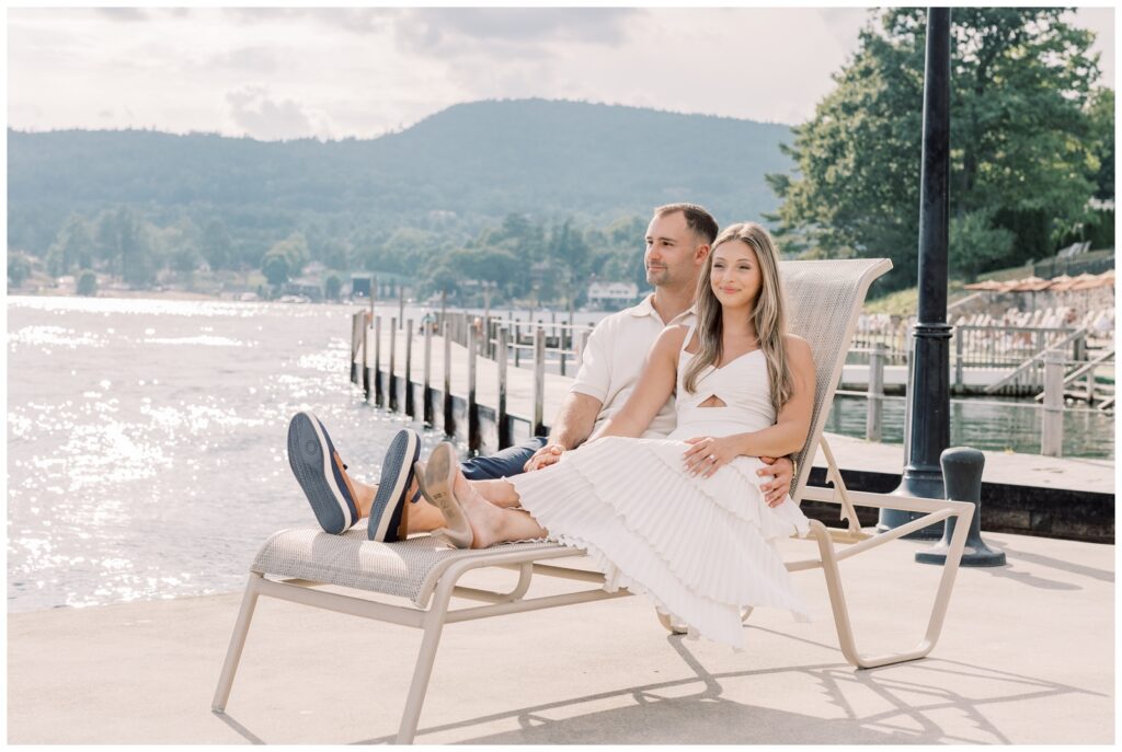 Couple relaxing on a lounge chair watching the sunset in Bolton Landing at The Sagamore Resort.
