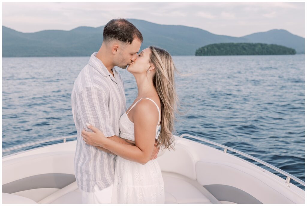 Couple kissing on a boat on Lake George.
