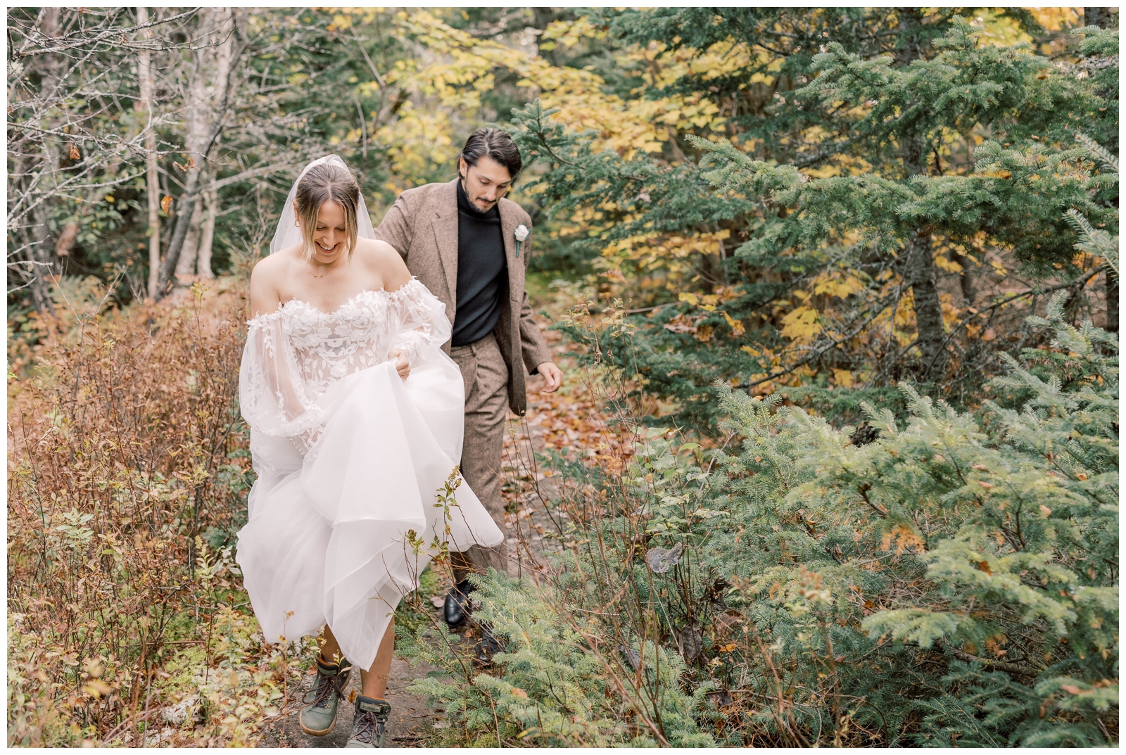 Bride and Groom hiking in their wedding attire to get to the peak of a mountain.
