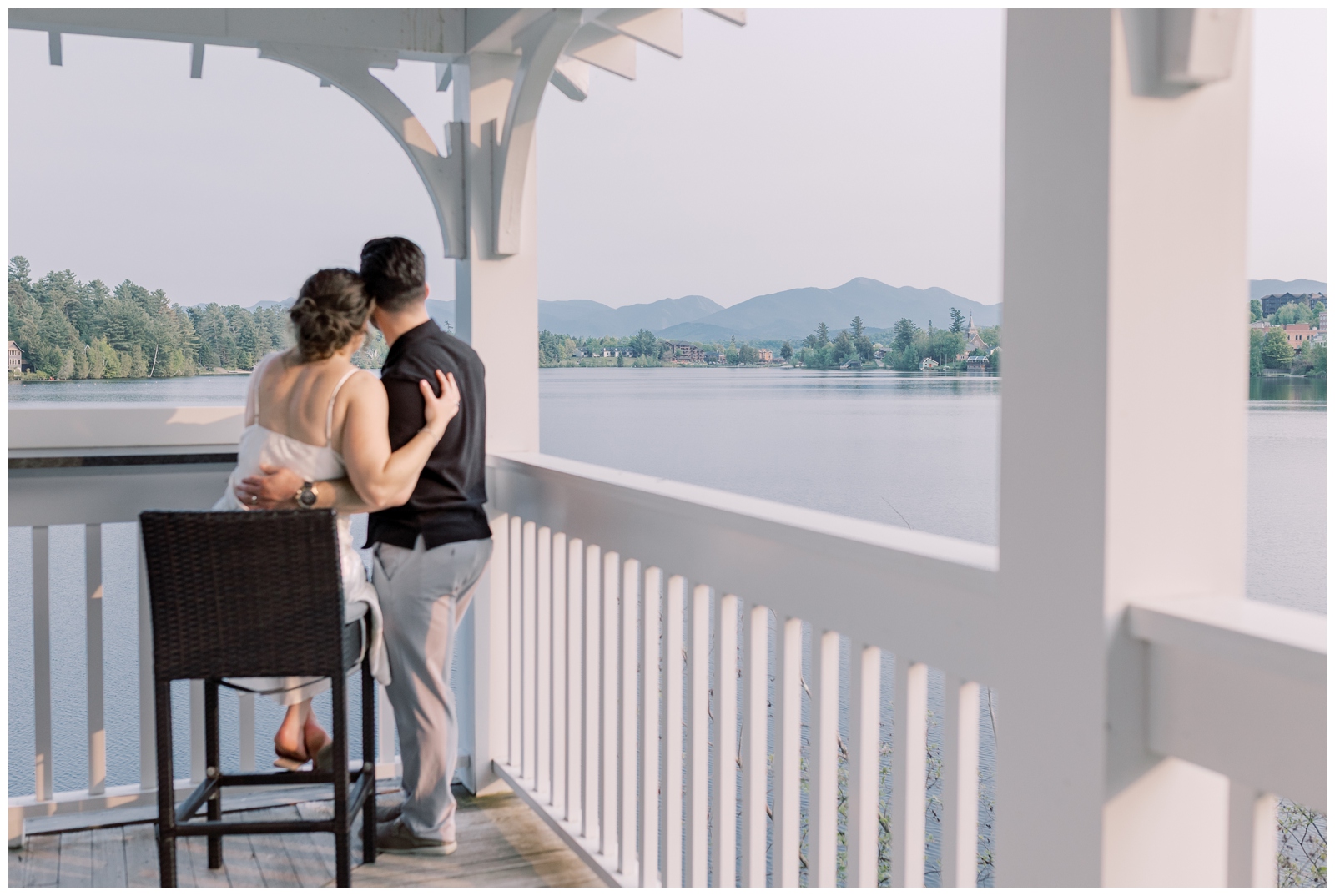 Couple sitting on a balcony over looking the lake with mountains in the background at Mirror Lake Inn

