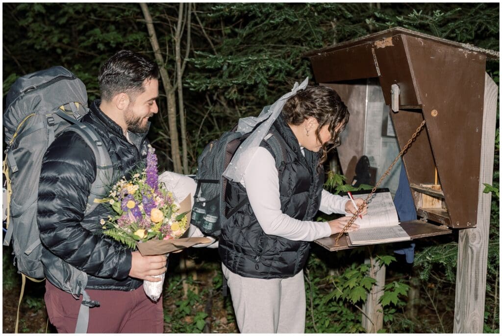 A couple signing in to begin their sunrise hike in Upstate New York. This blog talks about how to plan the perfect sunrise elopement.