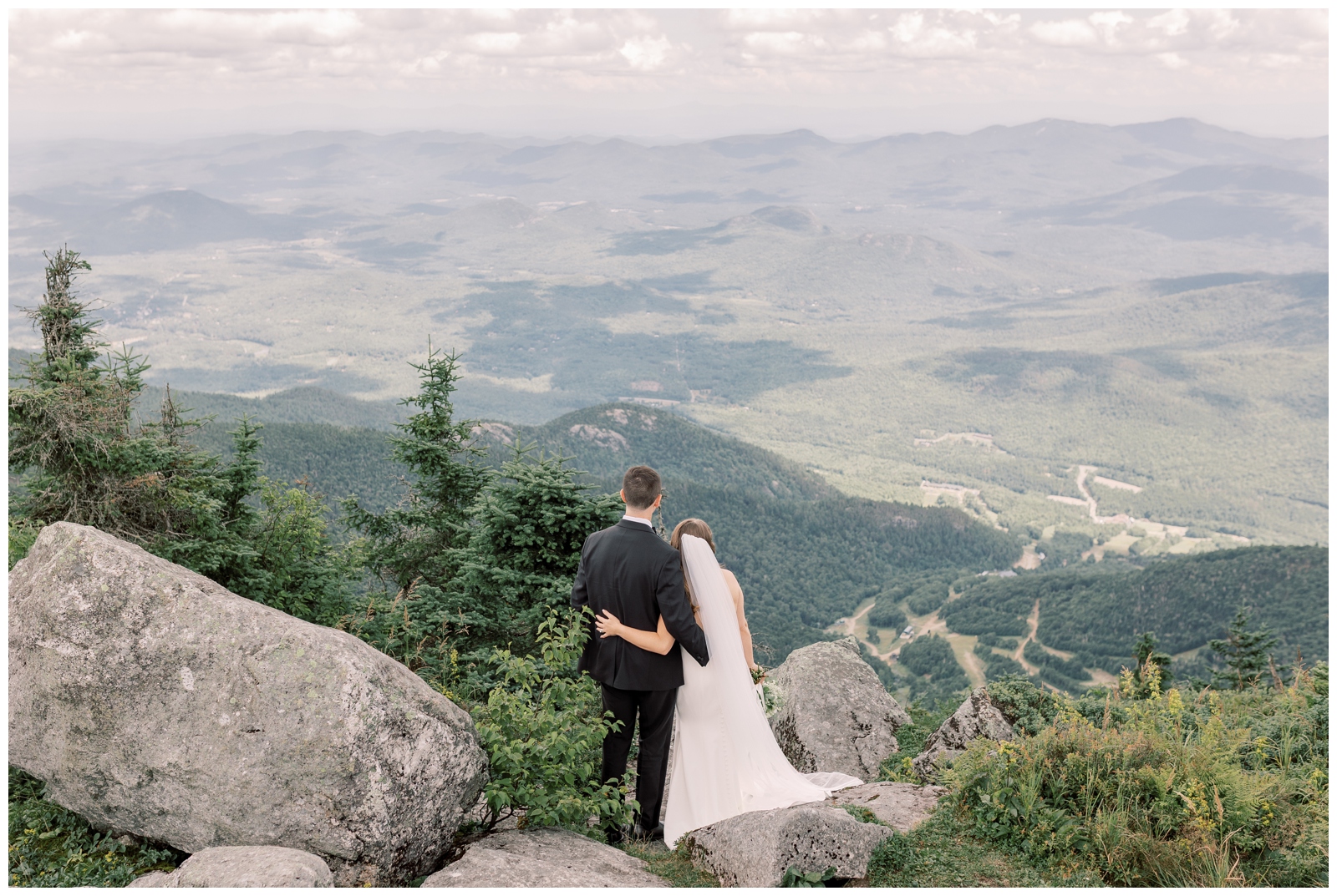 Bride and Groom looking out and the mountainous view on top of Whiteface Mountain during their elopement in Lake Placid.