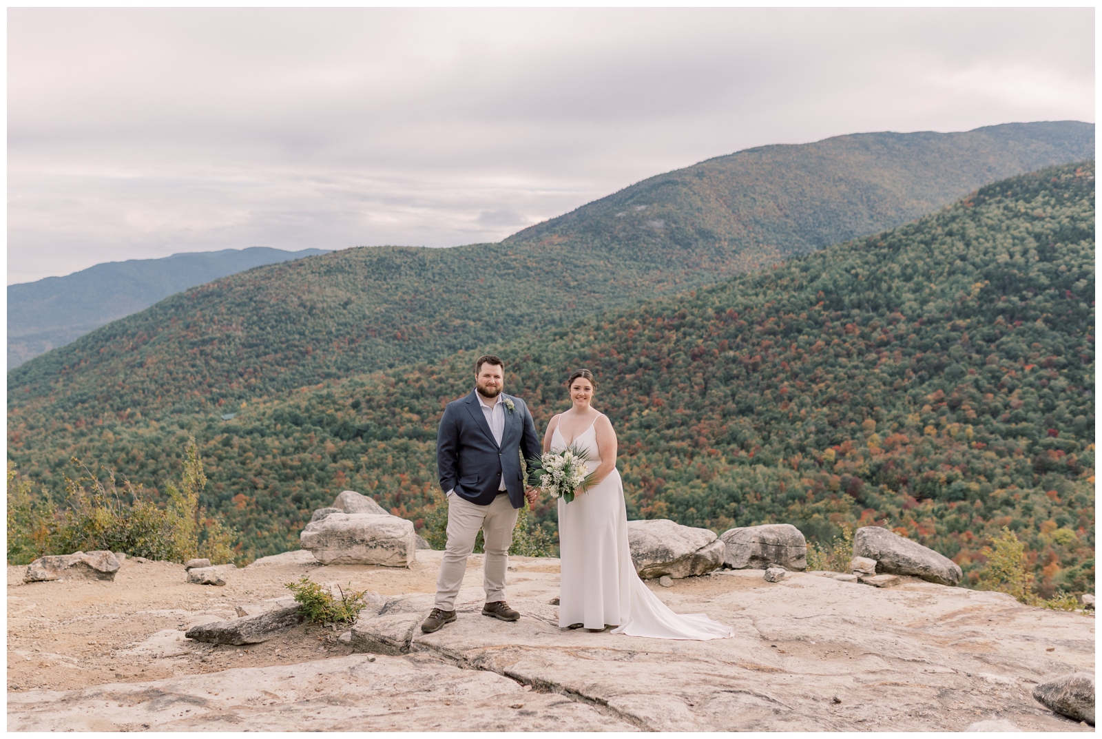 On top of cobble lookout mountain a couple poses during their hiking elopement in Lake Placid, NY.