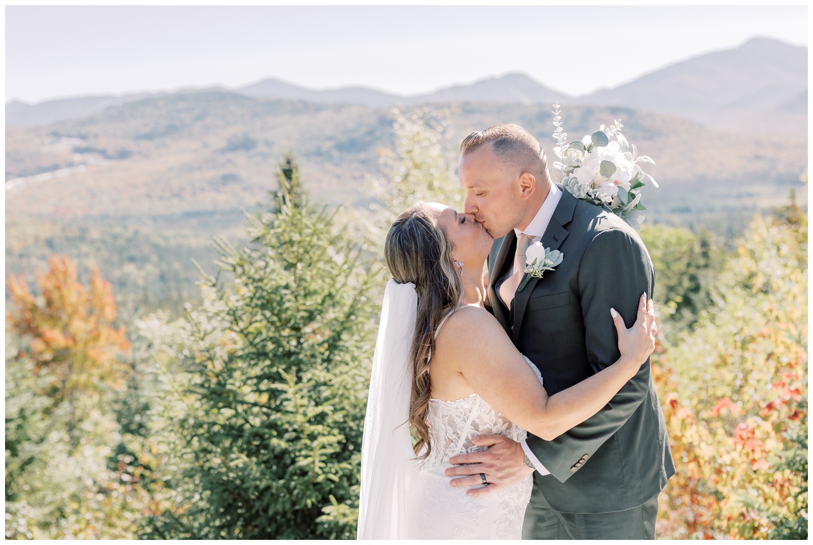 Couple kissing during their elopement at Experience Outdoors in Lake Placid with an Adirondack mountain view.

